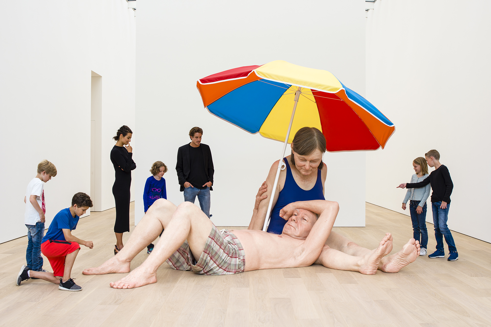 Kinderen kijken naar het kunstwerk Couple under an Umbrella van Ron Mueck 